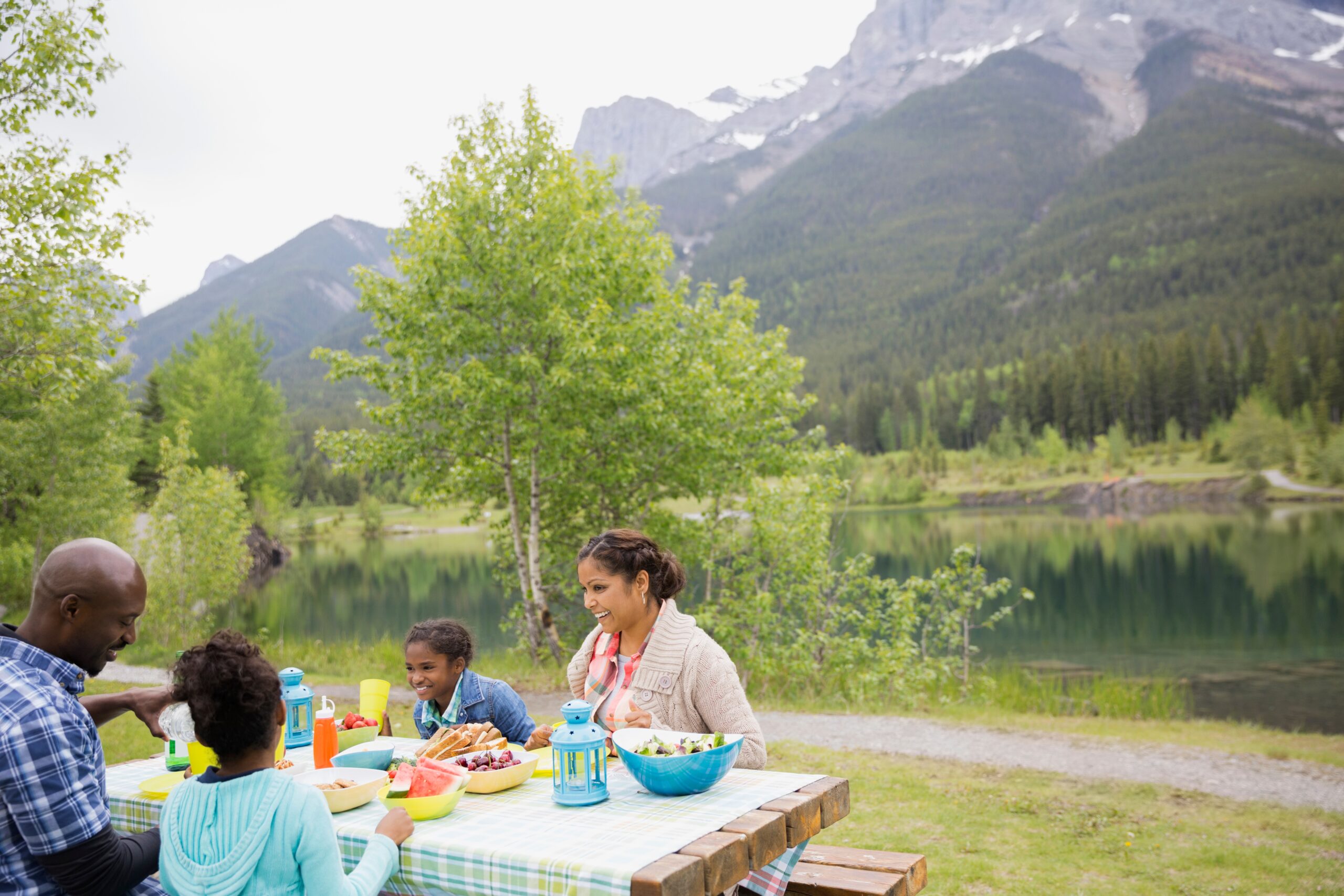 Family Eating At Picnic Table Near Lake 2026 03 26 04 45 12 Utc
